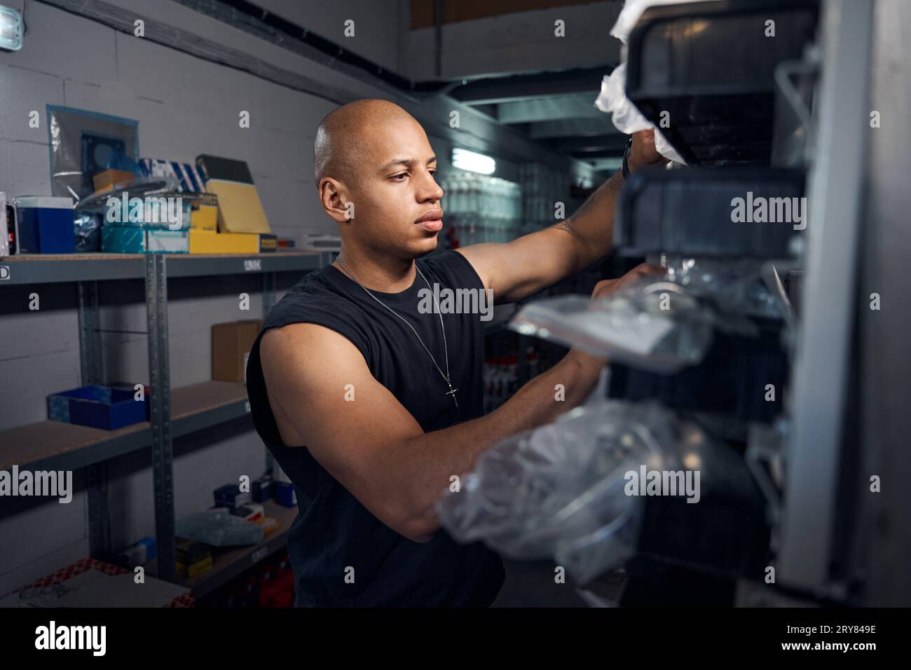 African American automechanic looking for needed spare part in