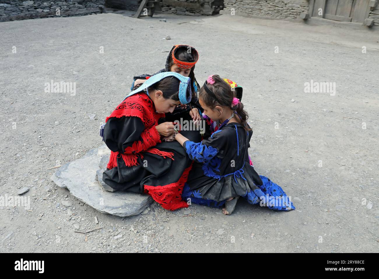 Kalash girls painting their hands with henna in preparation for the summer festival of Uchal Stock Photo