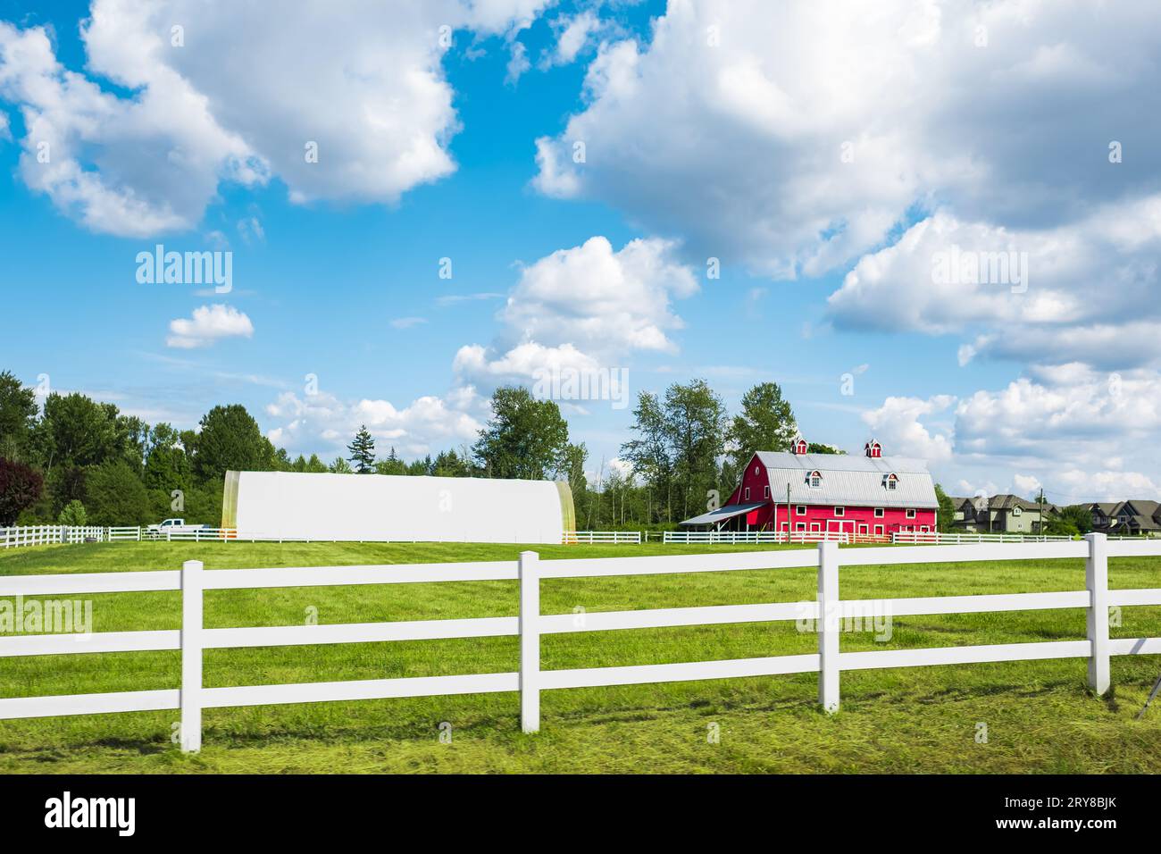 Agriculture Landscape With Old Red Barn. Traditional North American Farmland With Blue Cloudy Sky. Countryside in rural Canada Stock Photo