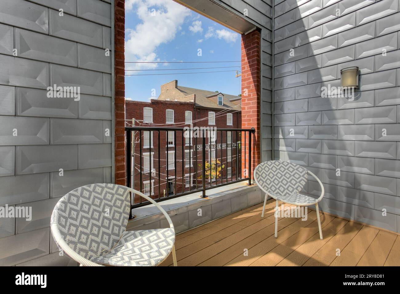 View of Metal Accent Wall on Outdoor Balcony with Lounge Chairs with Open ...