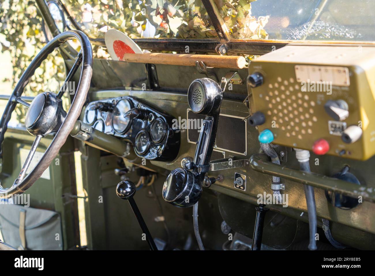 Interior of an old green military jeep covered with camouflage netting Stock Photo