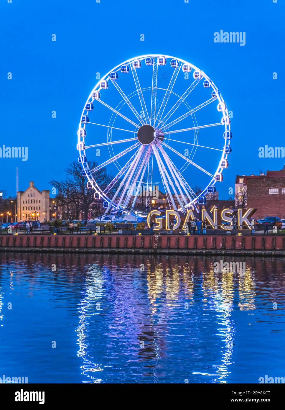 Colorful Ferris Wheel Illuminated Night Sign Inner Harbor Port Motlawa River Historic Old Town of Gdansk Poland. City formerly known as Danzig. Stock Photo