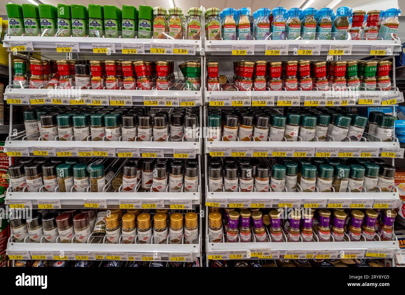 Italy - July 29, 2023: Cooking Spices of various kinds in glass bottles displayed on shelves for sale in Italian supermarket Stock Photo