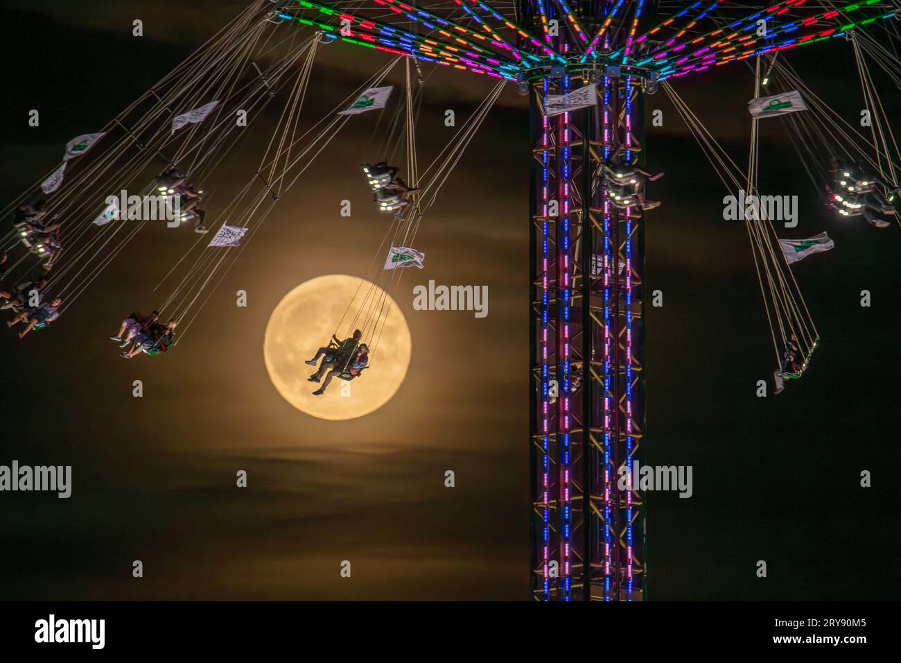 Supermond, Kettenkarussell vor Vollmond am Wiesnhimmel, Oktoberfest, München, 29. September 2023 Deutschland, München, 29. September 2023, Kettenkarussell vor Supermond, Wiesnbesucher fliegen in knapp 80 Metern Höhe am Vollmond vorbei, Freitagabend, das Hochkettenkarussell Jules Verne Tower ist seit 2017 auf dem Oktoberfest, Nachthimmel über München, der Mond ist besonders hell und groß, weil er in seiner Umlaufbahn am erdnächsten Punkt ist, Bayern, Volksfest, *** Supermoon, chain carousel in front of full moon in the Wiesn sky, Oktoberfest, Munich, 29 September 2023 Germany, Munich, 29 Septem Stock Photo