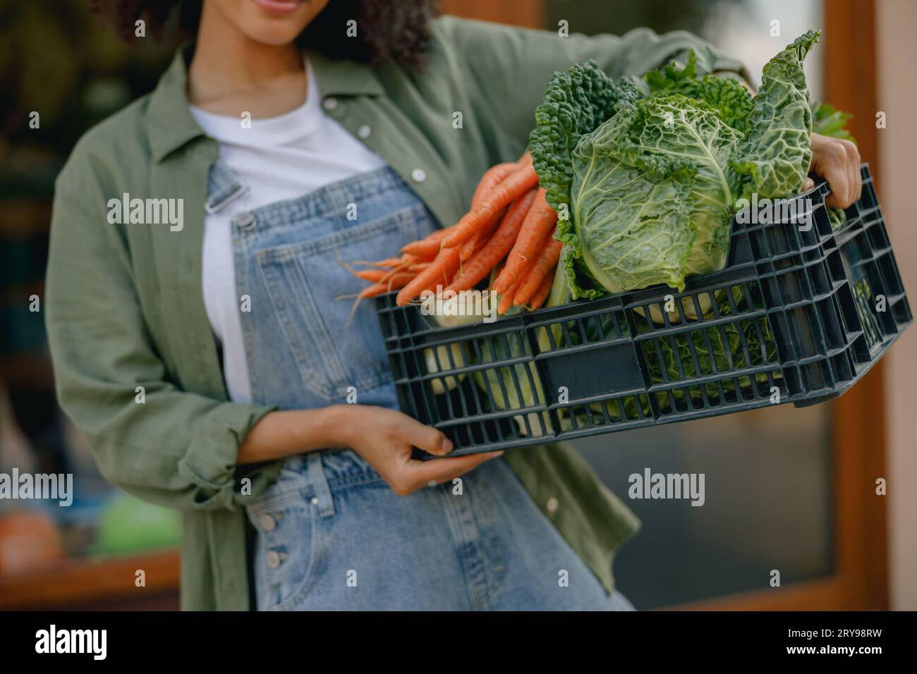 Close up of woman farmer with just harvested vegetables basket ready to ...