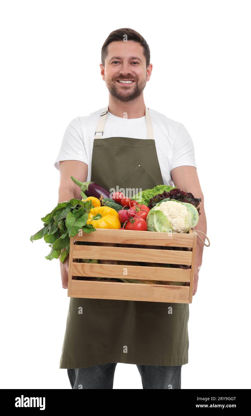 Harvesting season. Happy farmer holding wooden crate with vegetables on ...