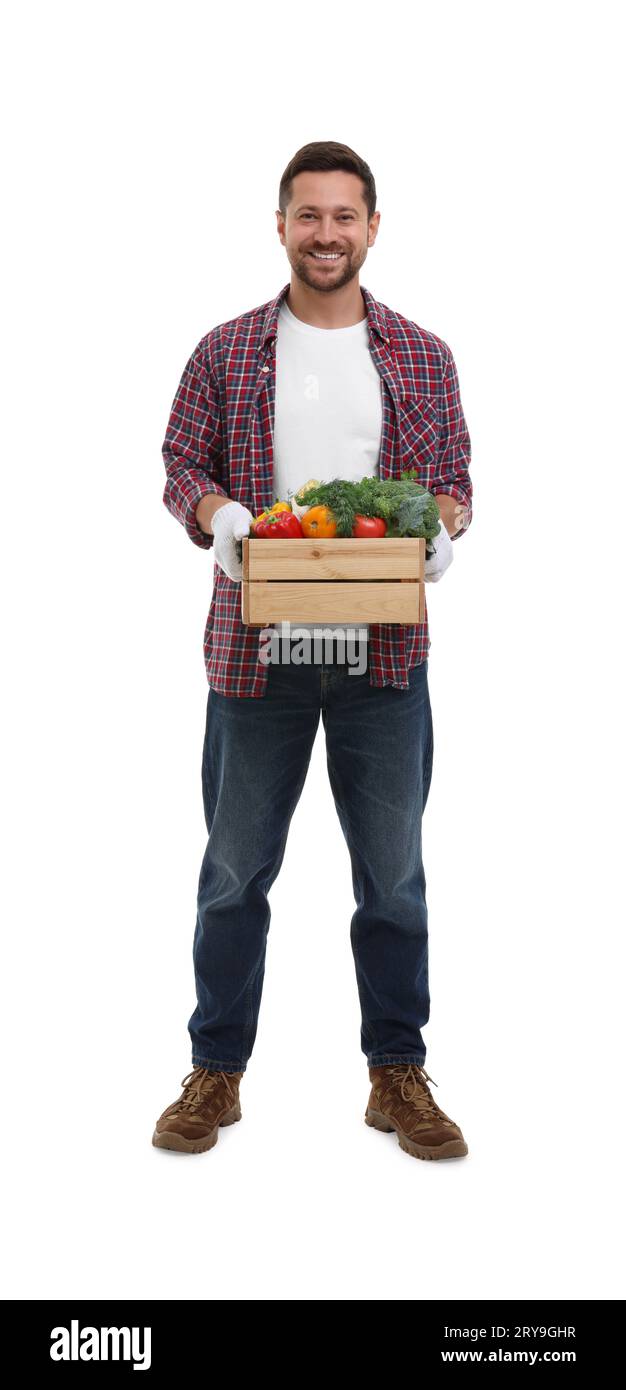 Harvesting season. Happy farmer holding wooden crate with vegetables on ...