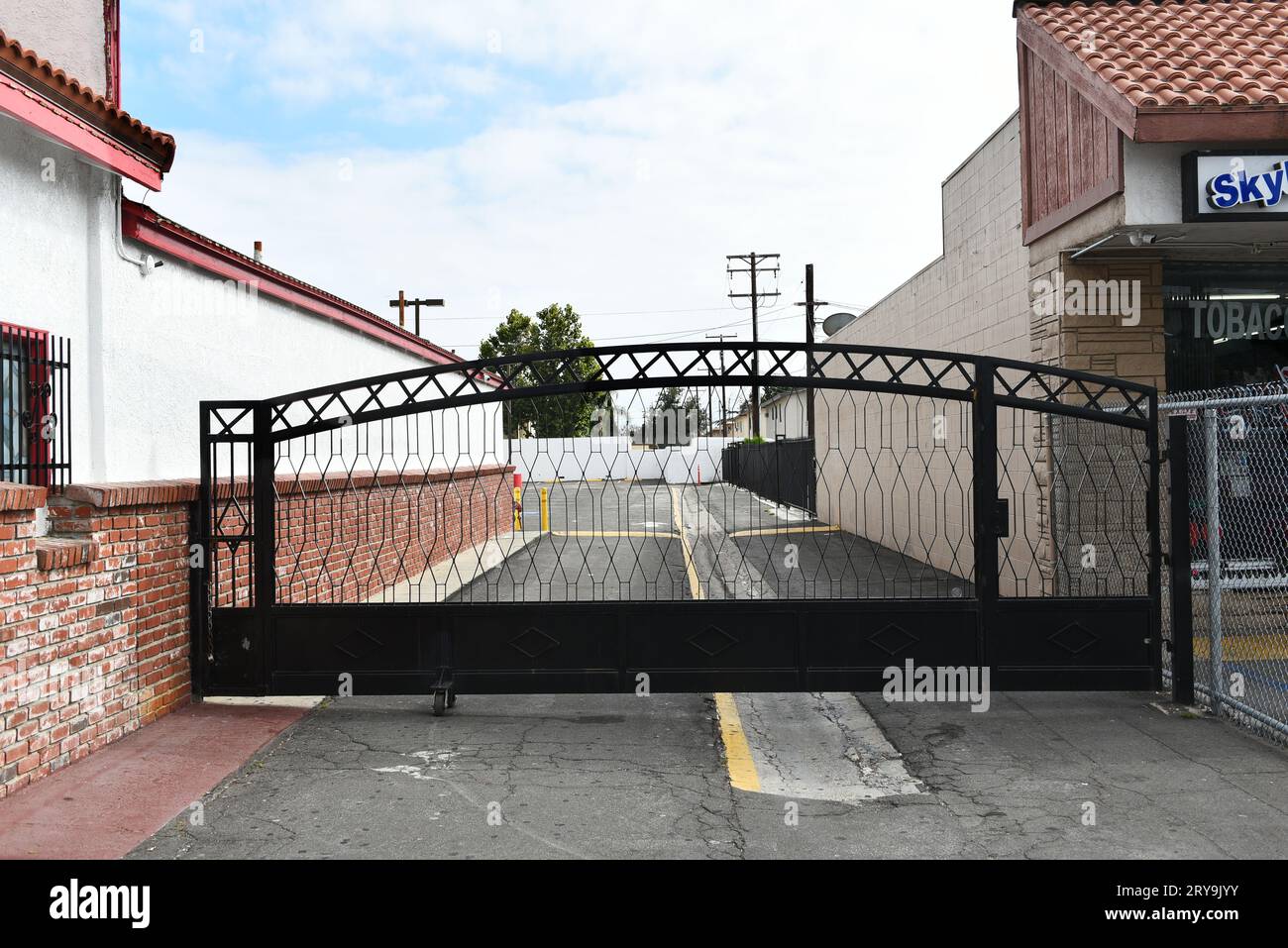ANAHEIM, CALIFORNIA - 17 SEPT 2023: Gate closing off an alley and parking lot at El Calor Night Club on Lincoln Avenue. Stock Photo