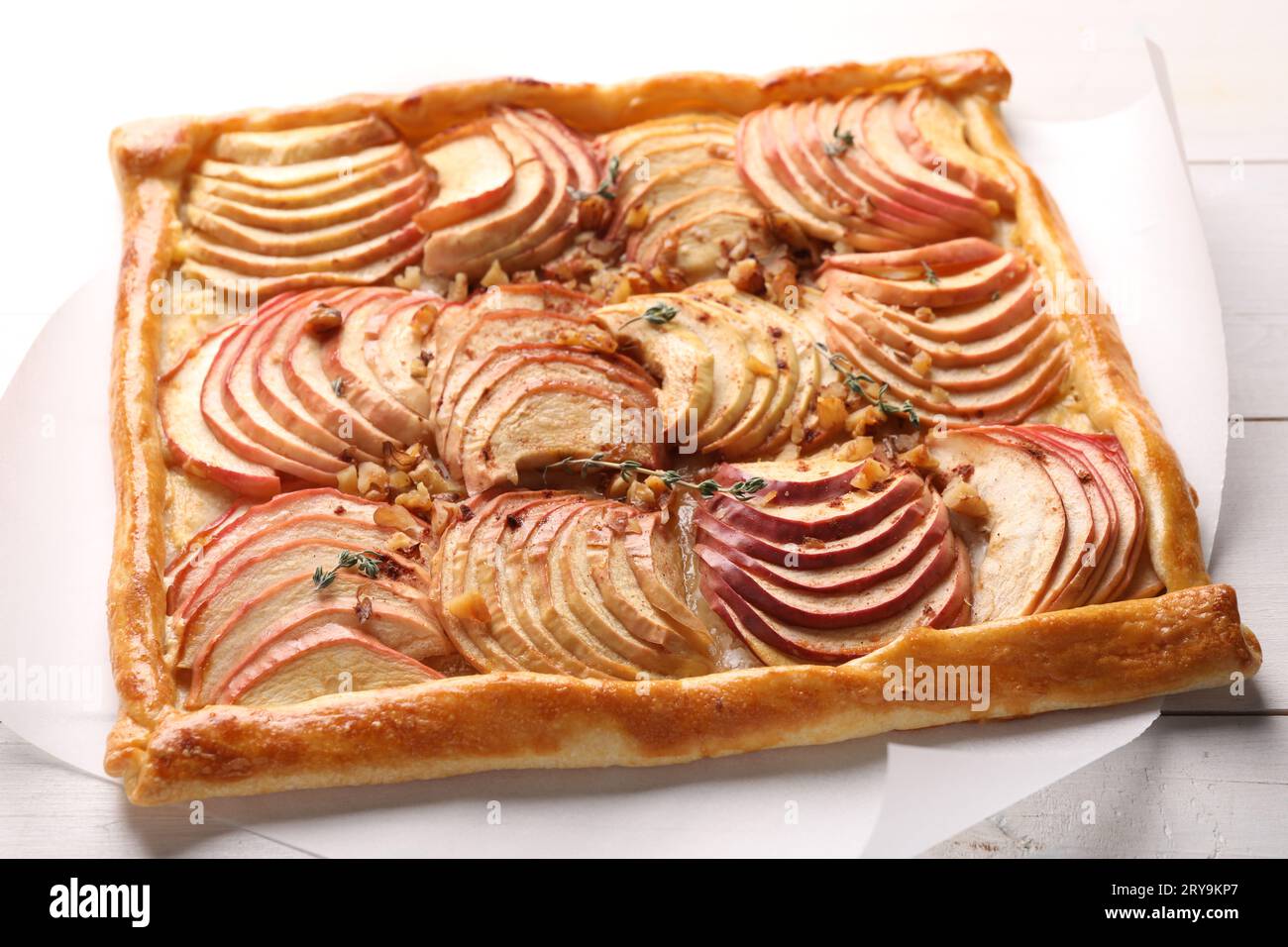 Freshly baked apple pie with nuts on white wooden table, closeup Stock Photo
