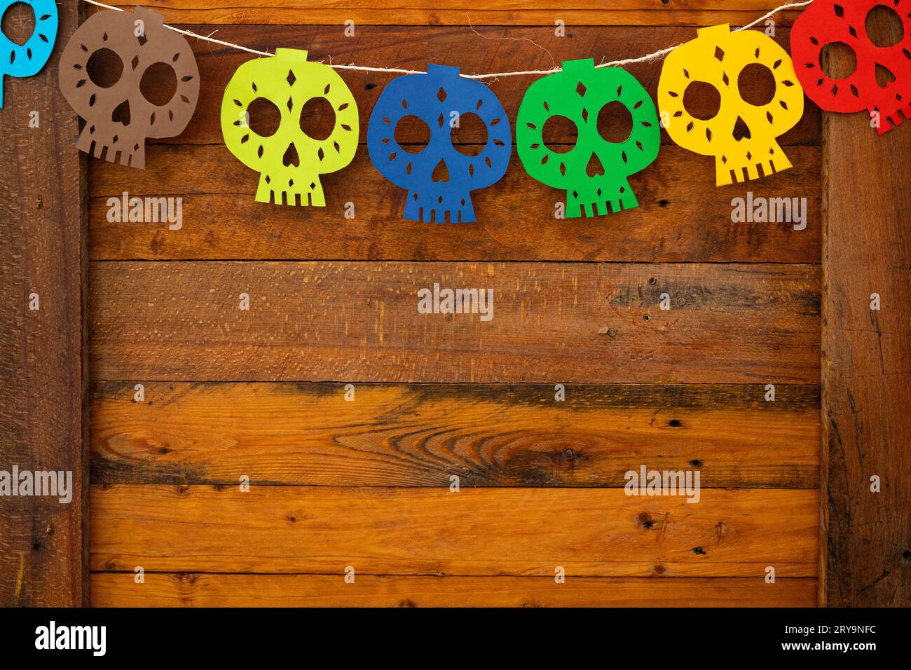 decoration of skulls of various colors made of paper on a wooden background Stock Photo