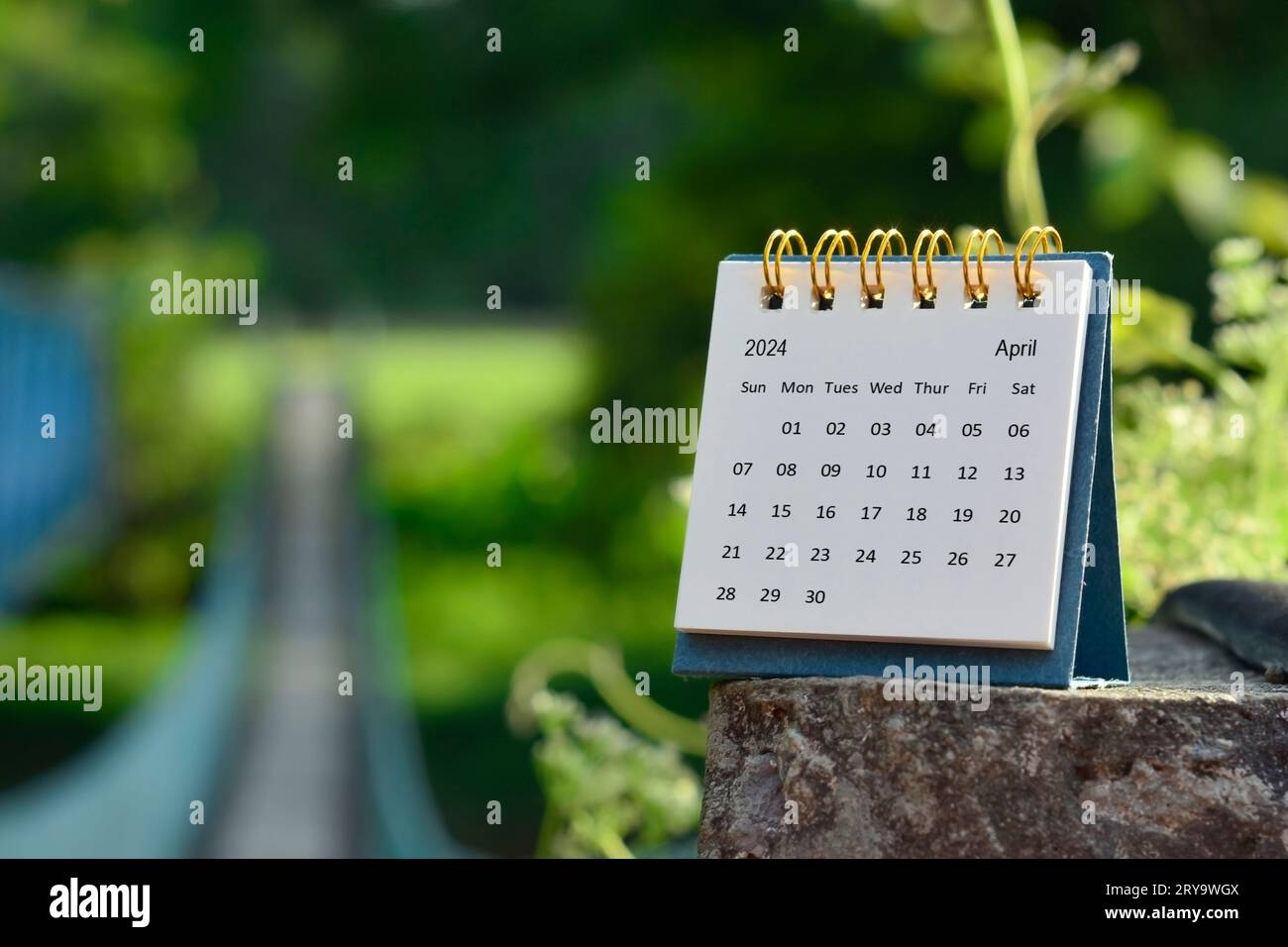 April 2024 calendar with green blurred background of hanging bridge