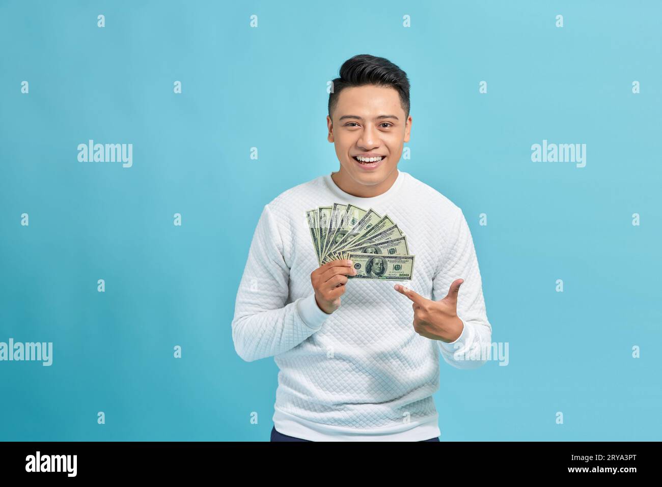 happy man with money fan, standing isolated against blue background Stock Photo
