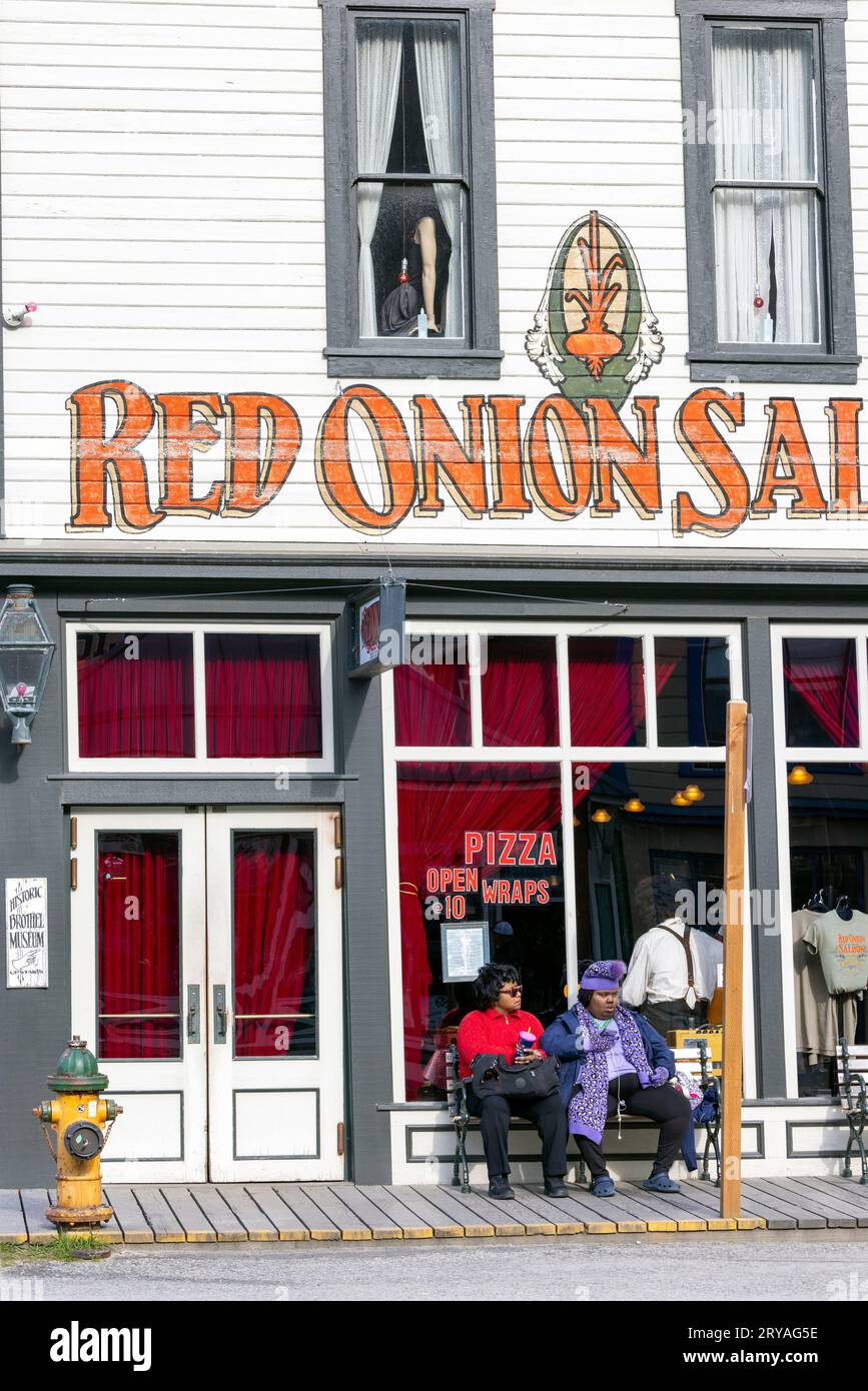 Women sitting in front of the historic Red Onion Saloon in Skagway, Alaska, USA Stock Photo