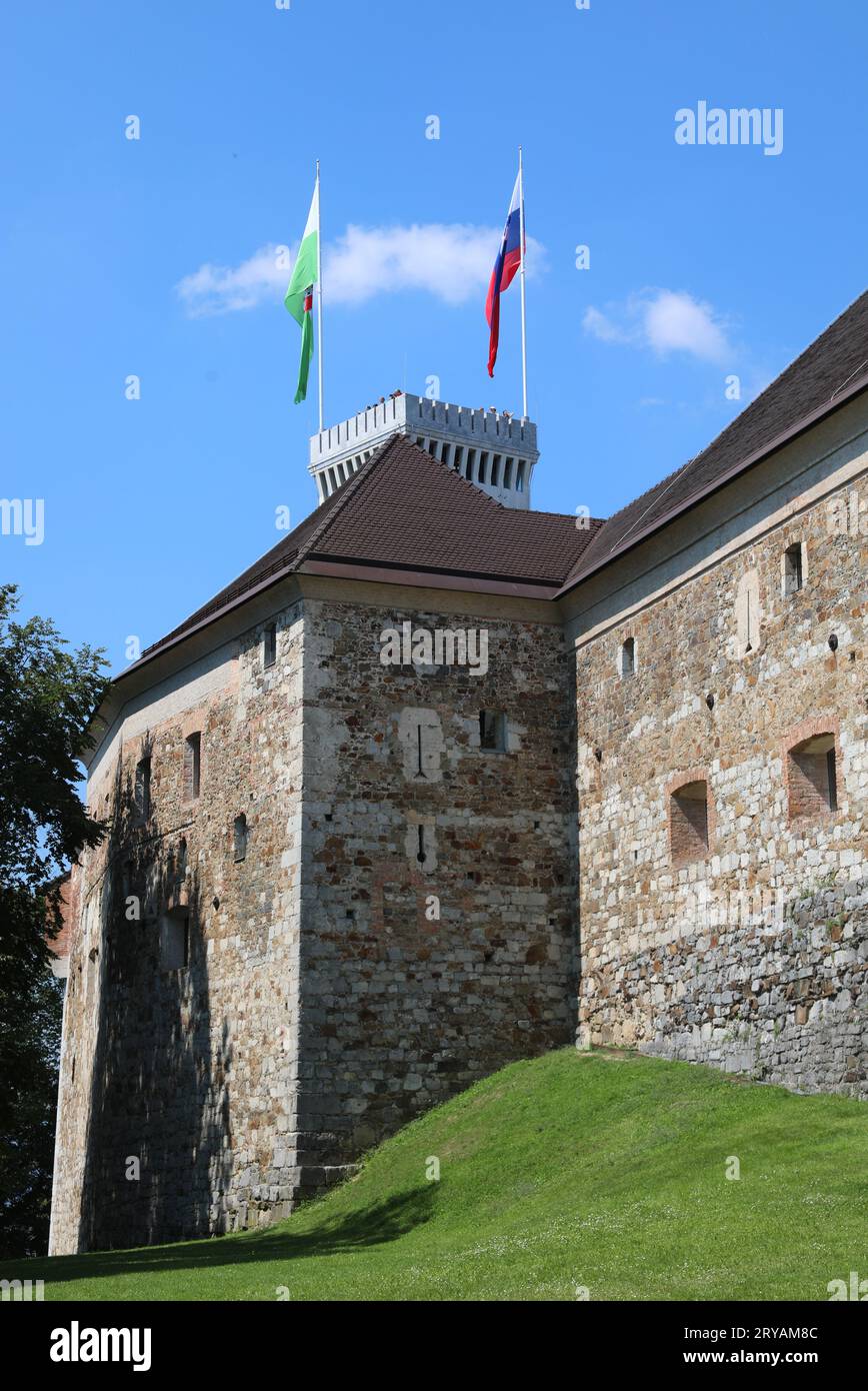 Ljubljana, L, Slovenia - August 15, 2023:  Tower of ancient Castle called ljubljanski grad in Slovenian language and flags Stock Photo