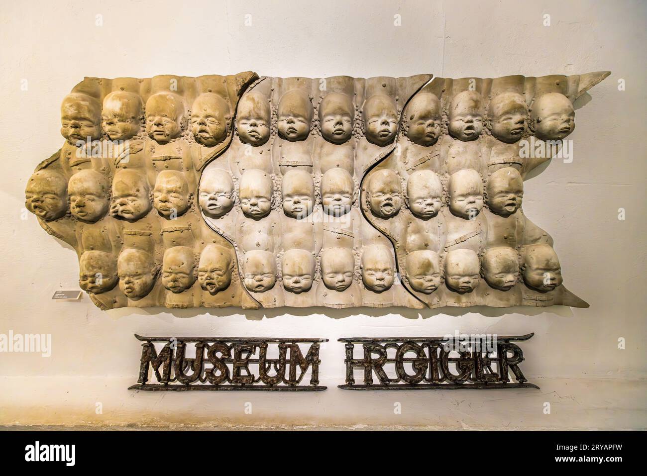 Entrance HR Giger Museum Gruyères, museum lettering and wall object made of infant masks. Hansrudi Giger received an Oscar in 1980 for his contribution to Alien. HR Giger Museum in Épagny Greyerz, Switzerland Stock Photo