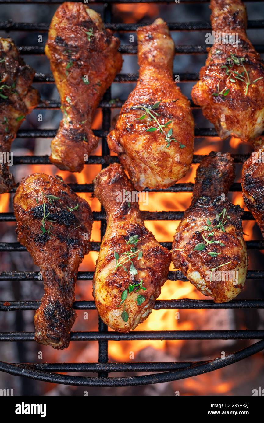 Grilled chicken leg on grill grate with fire. Grilled chicken leg on grate with fire Stock Photo