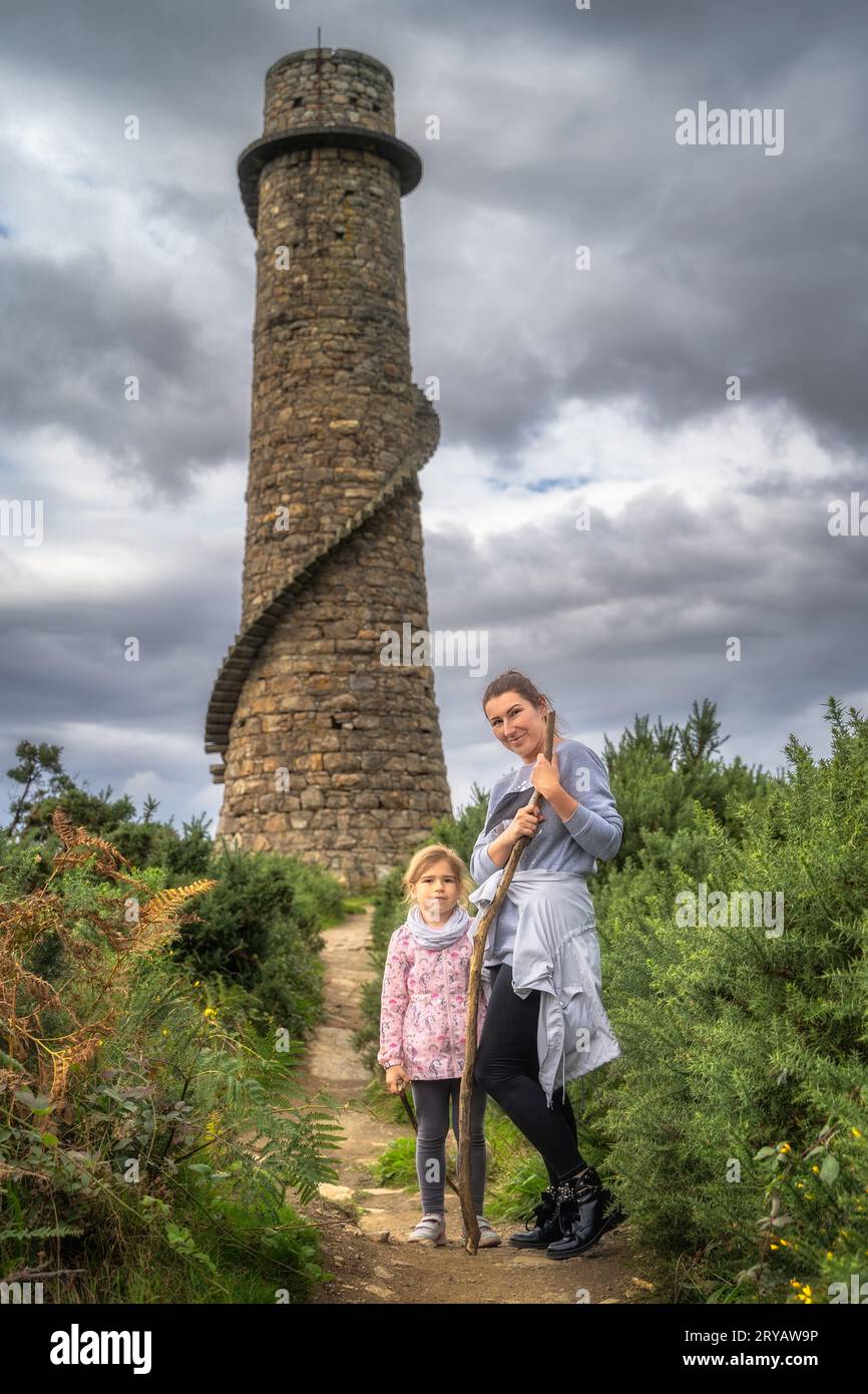 Mother and daughter standing in front of old and abandoned stone ...