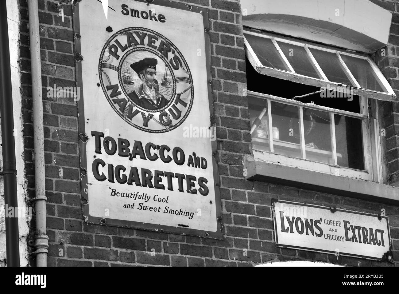 A black and white photograph of a vintage metal sign advertising