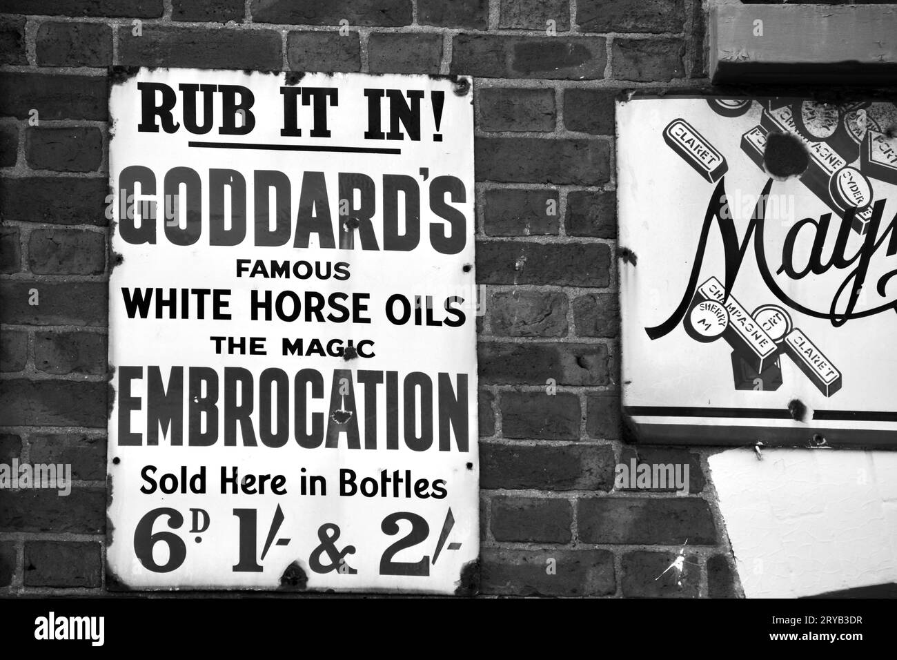 A black and white photo of a vintage metal sign advertising Goddards white horse oils. The advert gives the price in old money prior to decimalisation Stock Photo