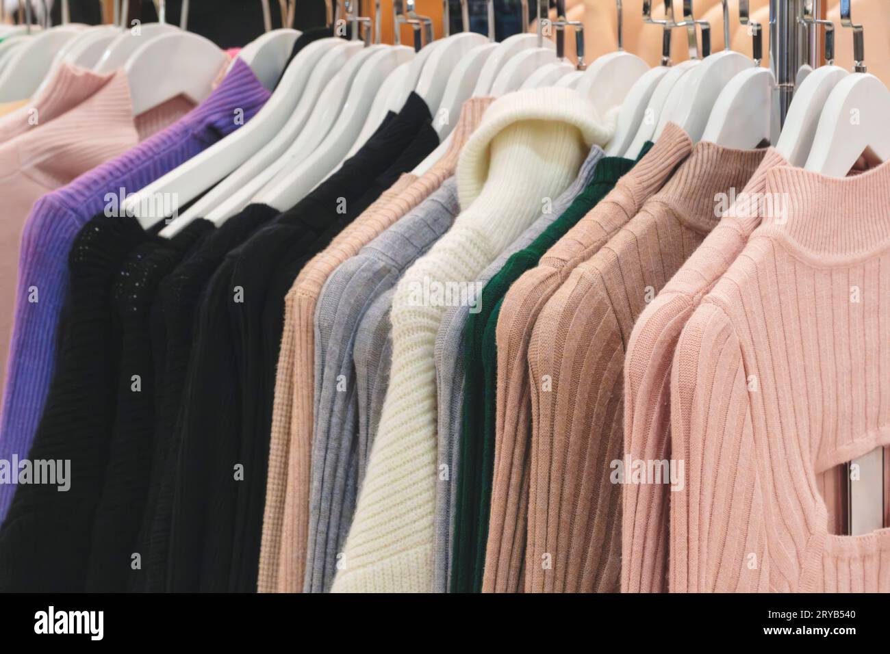 Women's sweaters on a hanger in a store. Classic women's fashion clothing. Stock Photo