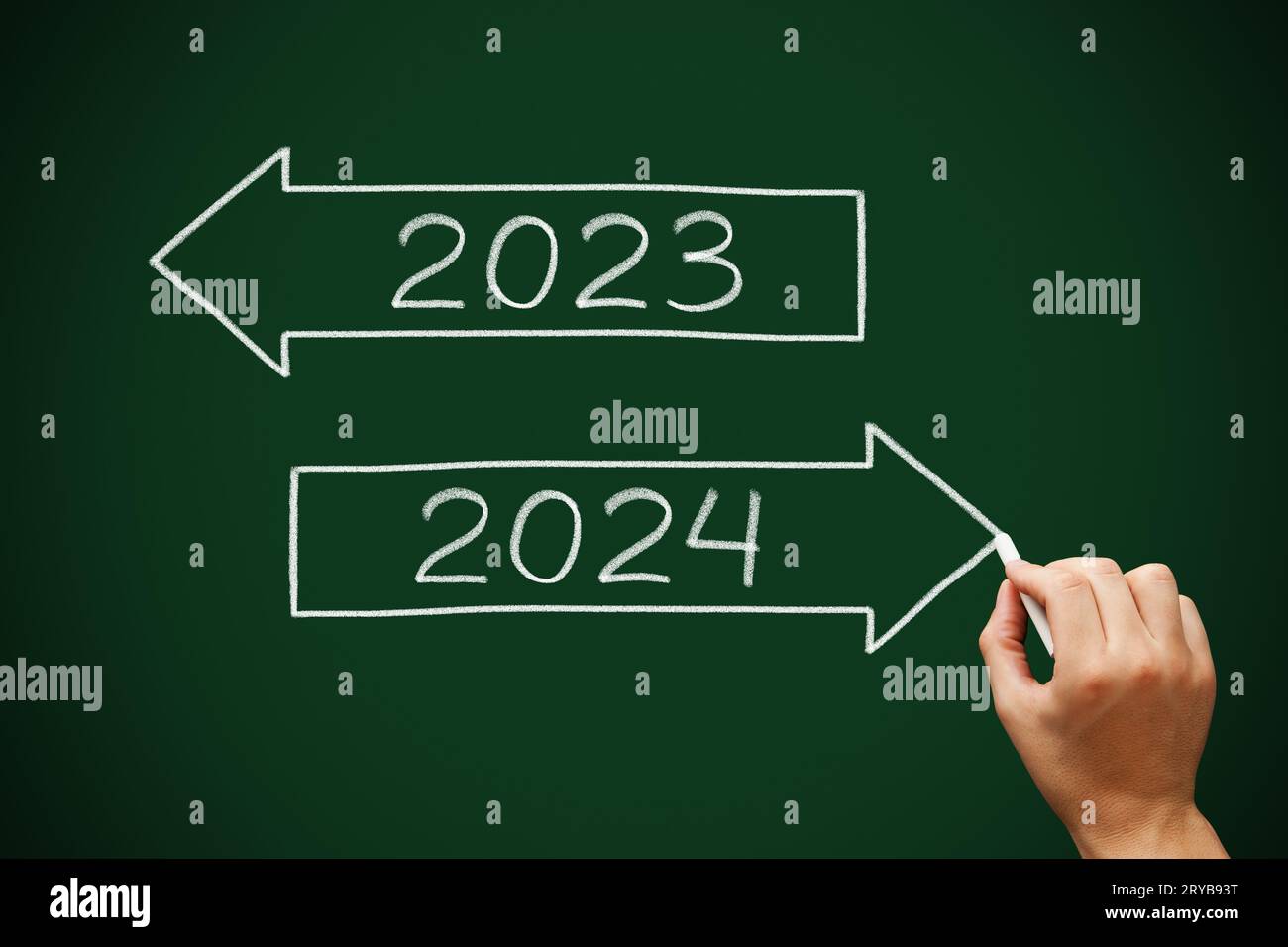 Hand drawing Happy New Year 2024 Goodbye 2023 two arrows concept with white chalk on green chalkboard. Stock Photo