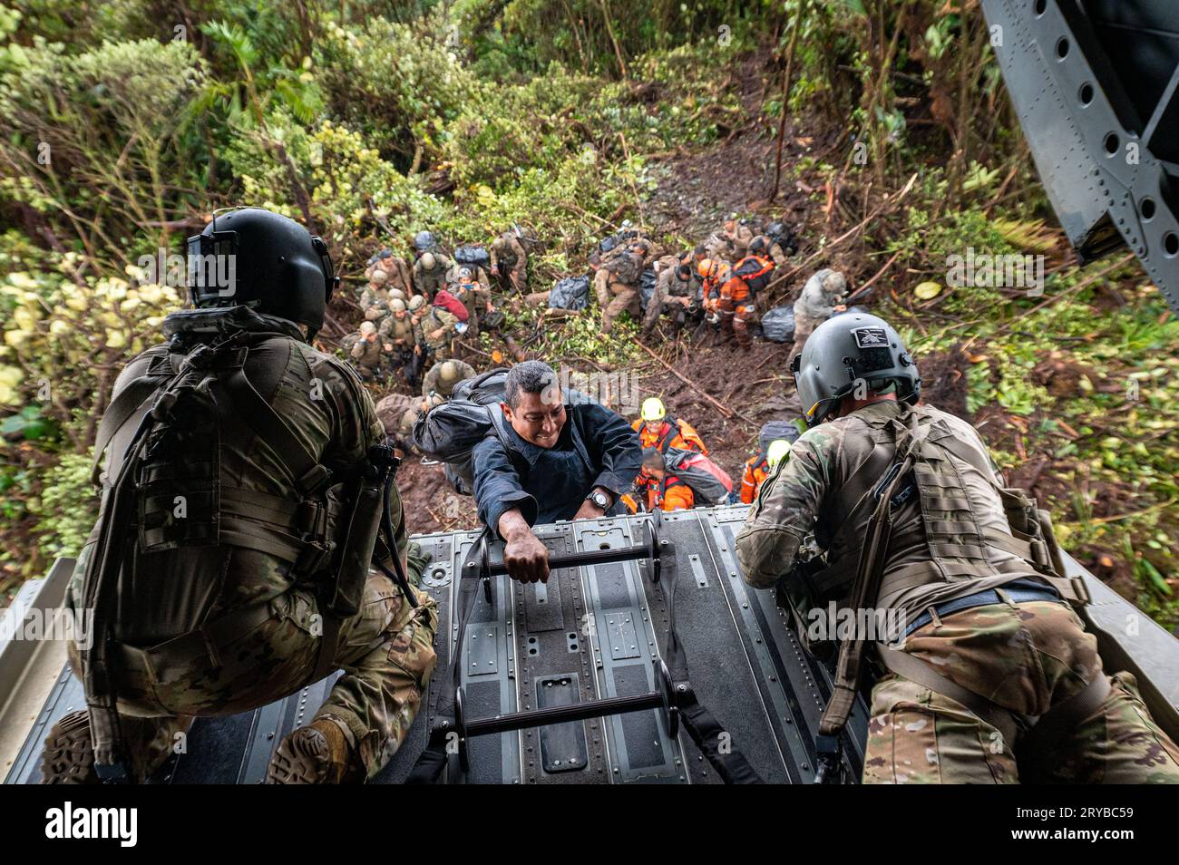 Olaon District, Panama. 15 September, 2023. A Bomberos de Panama search and rescue specialist ascends a ladder suspended from the ramp of a U.S Army CH-47 Chinook helicopter as it hovers a few feet above a landing zone atop a remote jungle mountain, September 15, 2023, in the Olaon District, Panama. The U.S. forces assisted in search and recovery of a crashed Servicio Nacional Aeronaval Leonardo AW-139 helicopter that crashed killing all three aboard.  Credit: TSgt. Duncan McElroy/U.S. Air Force/Alamy Live News Stock Photo