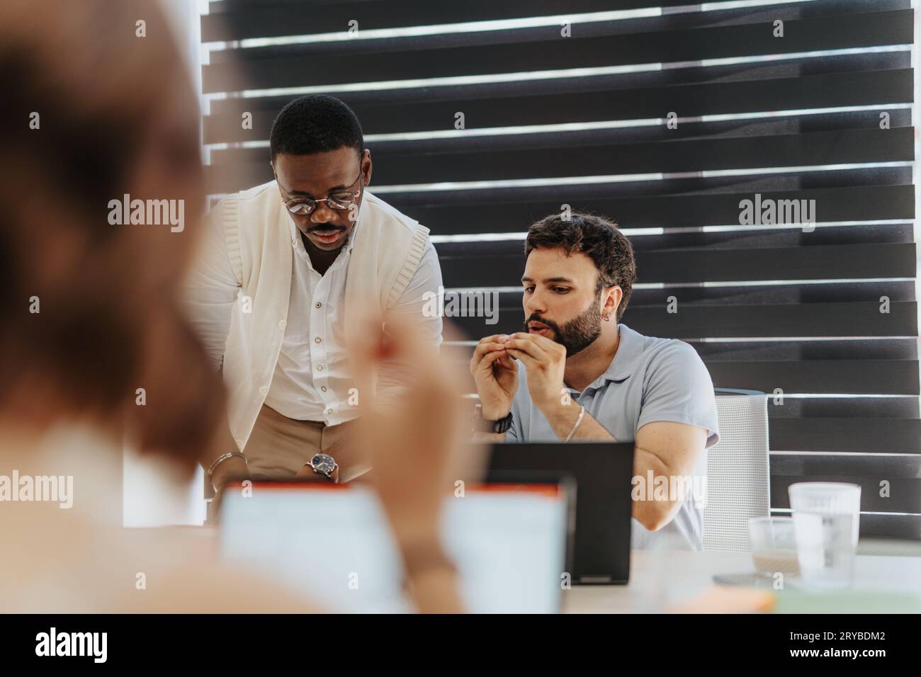 Concentrated multiracial colleagues working on project together at the office. Teamwork concept. Stock Photo