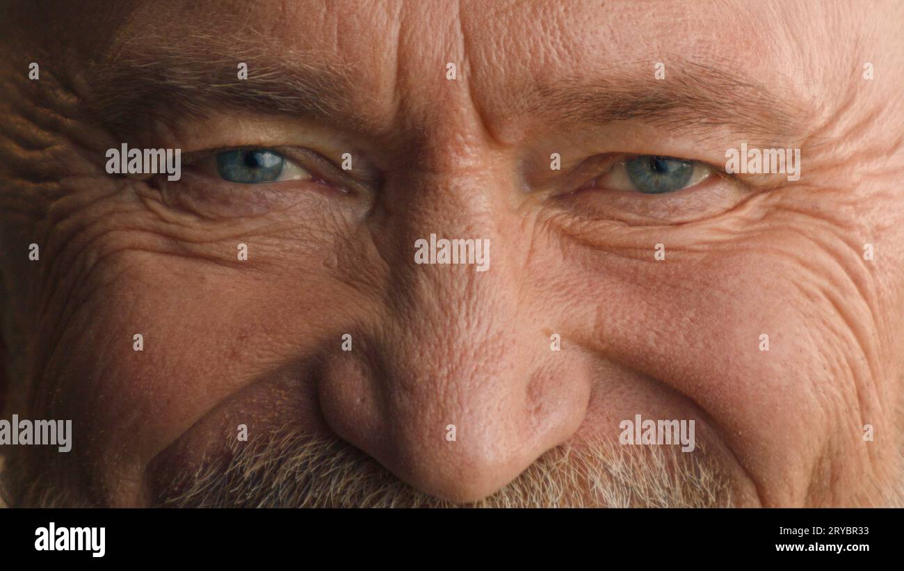 Close up Caucasian elderly male eyes wrinkled old mature senior man retired pensioner looking at camera smile happy vision good eyesight look smiling Stock Photo
