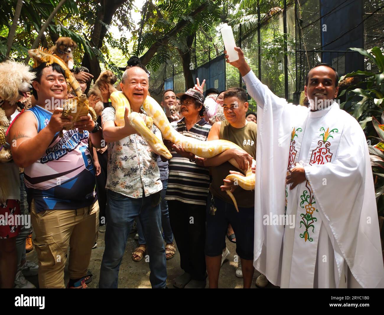 Malabon, Philippines. 30th Sep, 2023. Manny Tangco the founder of Malabon Zoo together with other pet owners carry their favorite pets during the pet blessing. Pet lovers and owners flock to Malabon Zoo to celebrate World Animal Day and Feast Day of St. Francis of Assisi, patron saint of animals. Led by Manny Tangco, founder of Malabon Zoo. He presents to media people, students & pet owners 'Sir George' the white lion cub, and 'Cheesecake', an albino Burmese python. They also conduct pet blessing & free anti-rabies vaccination to pets. Credit: SOPA Images Limited/Alamy Live News Stock Photo