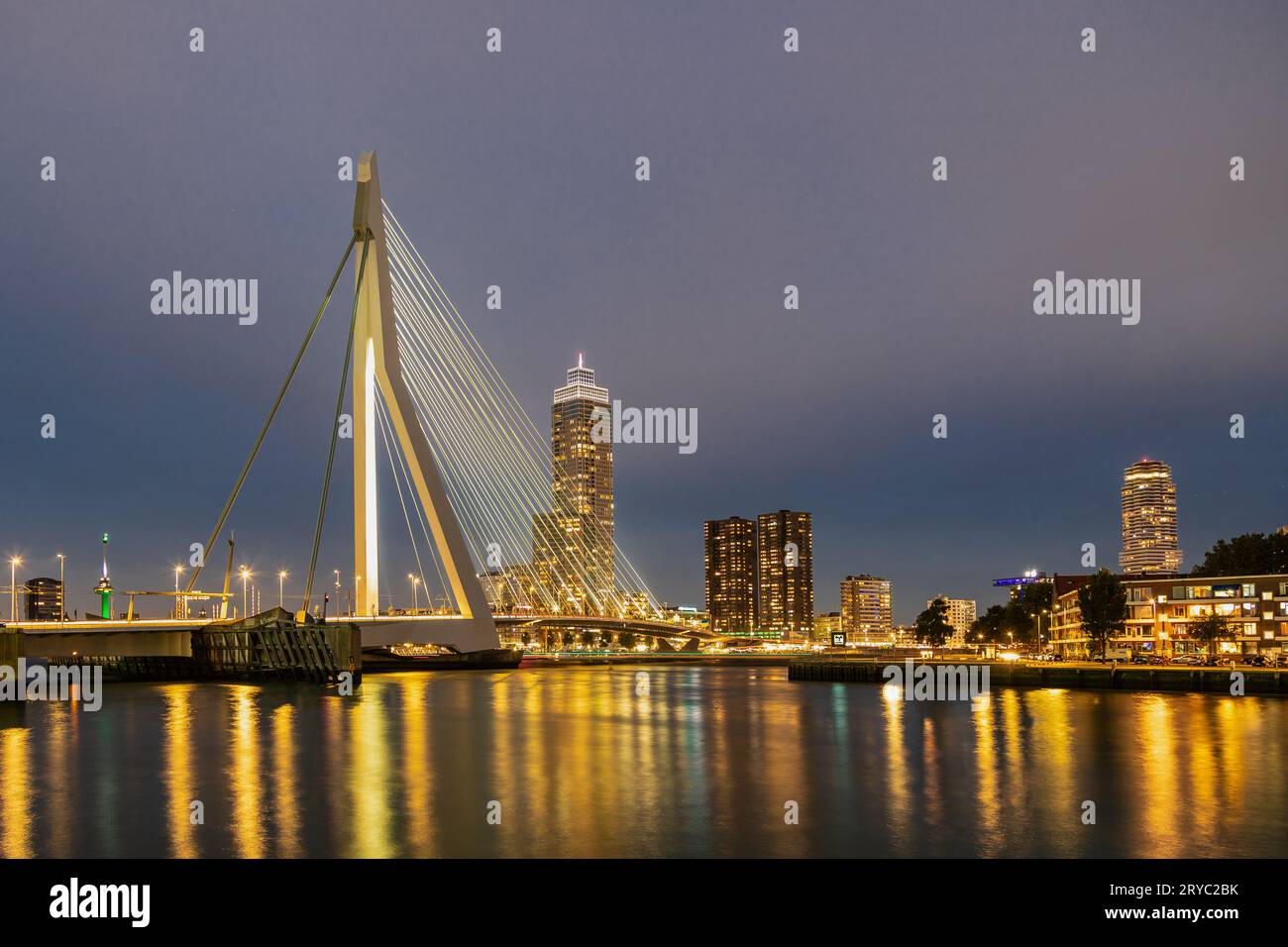 The Erasmus bridge, also know as the swan, a combined cable-stayed and bascule bridge in the centre of Rotterdam during sunset and early blue hour Stock Photo