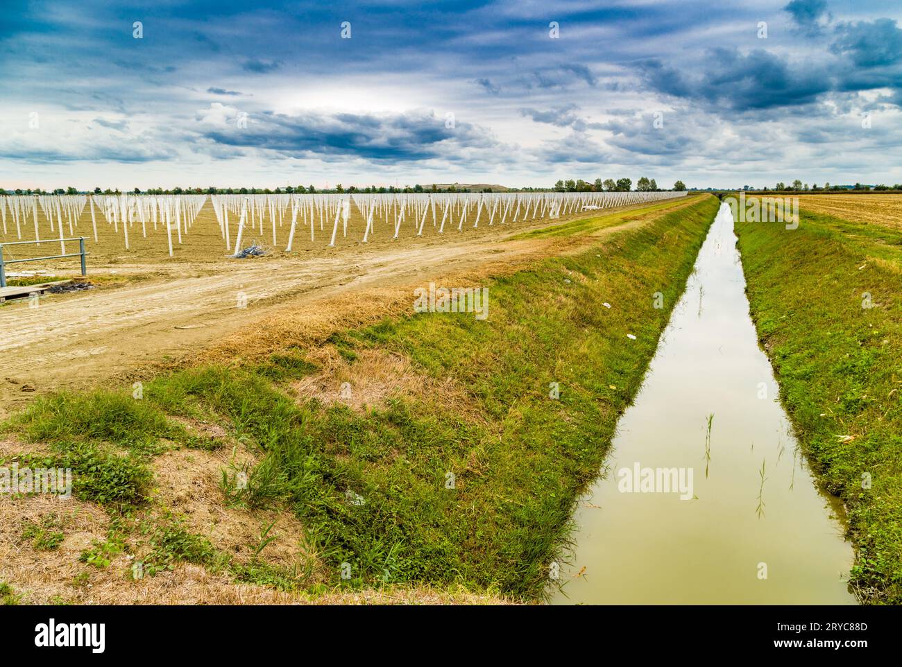 Irrigation canal divides harvested land and plowed land with precast