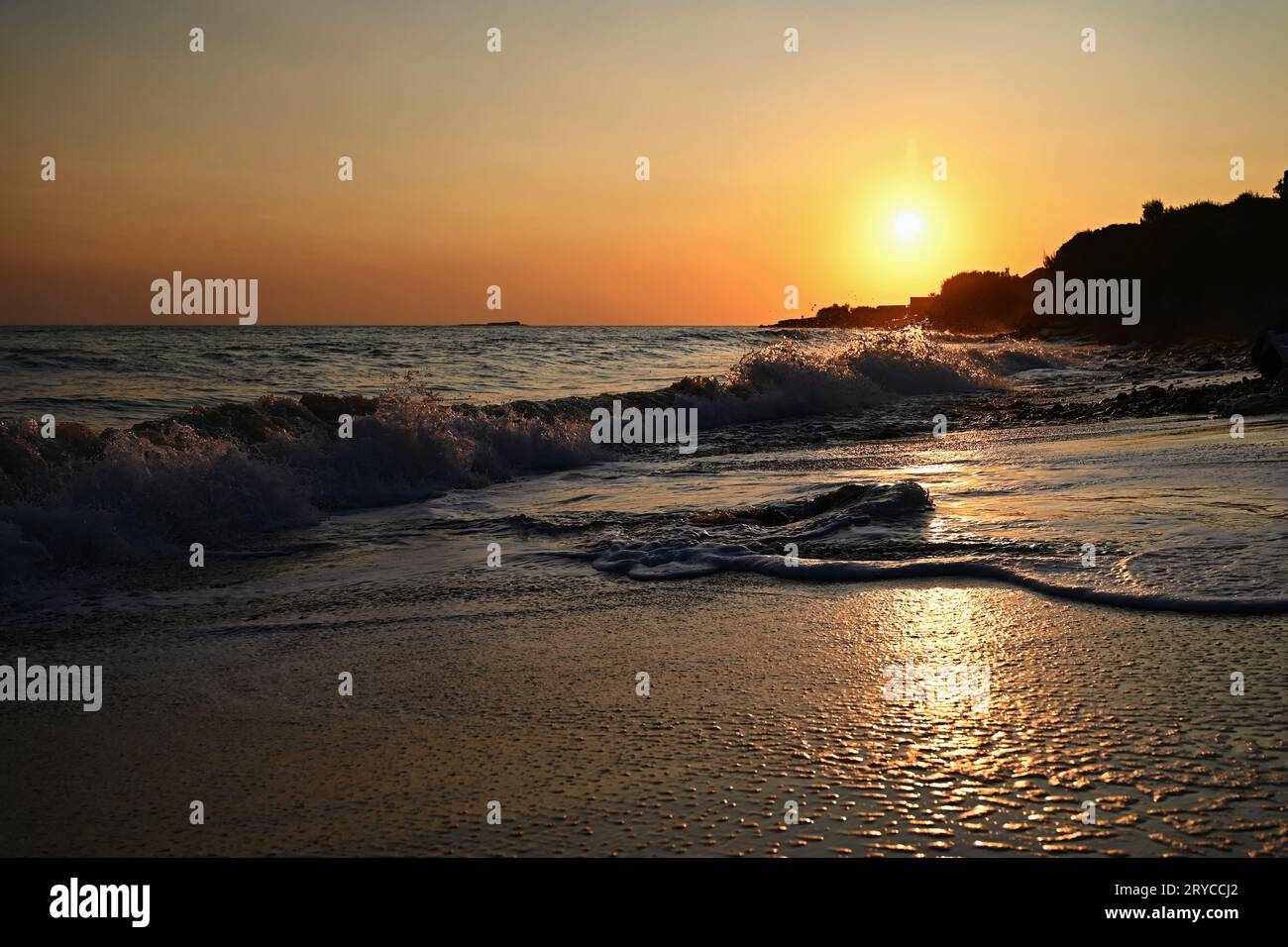 Beautiful sunset on the beach with the sea. Waves on the sea. Greece - Corfu island (Kerkyra) Agios Georgios. A concept for travel, holidays and summe Stock Photo