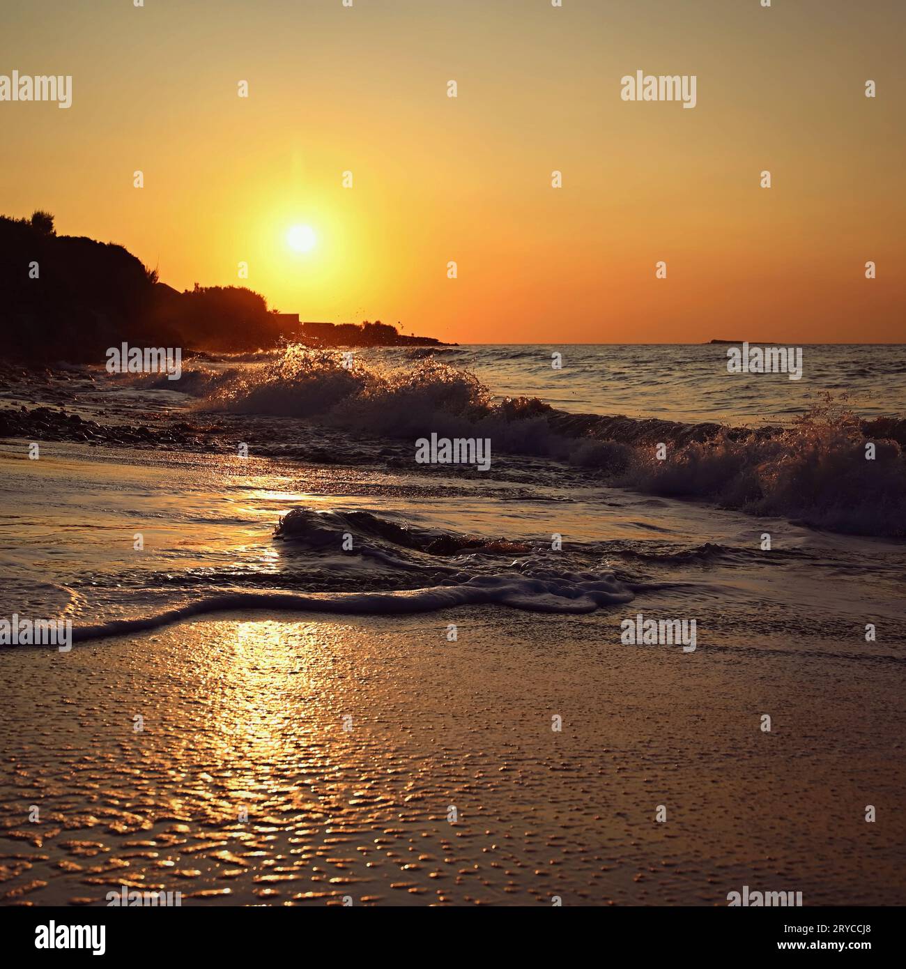 Beautiful sunset on the beach with the sea. Waves on the sea. Greece - Corfu island (Kerkyra) Agios Georgios. A concept for travel, holidays and summe Stock Photo