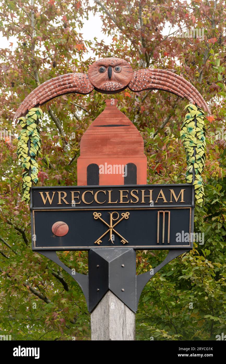 Wrecclesham village sign, Surrey, England, UK. The decorative sign has a pottery kiln, owl and cricket symbols recognising its historical associations Stock Photo