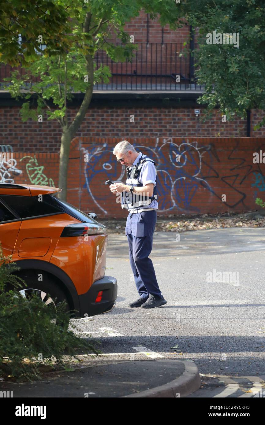Parking warden preparing to complete a ticket Stock Photo Alamy