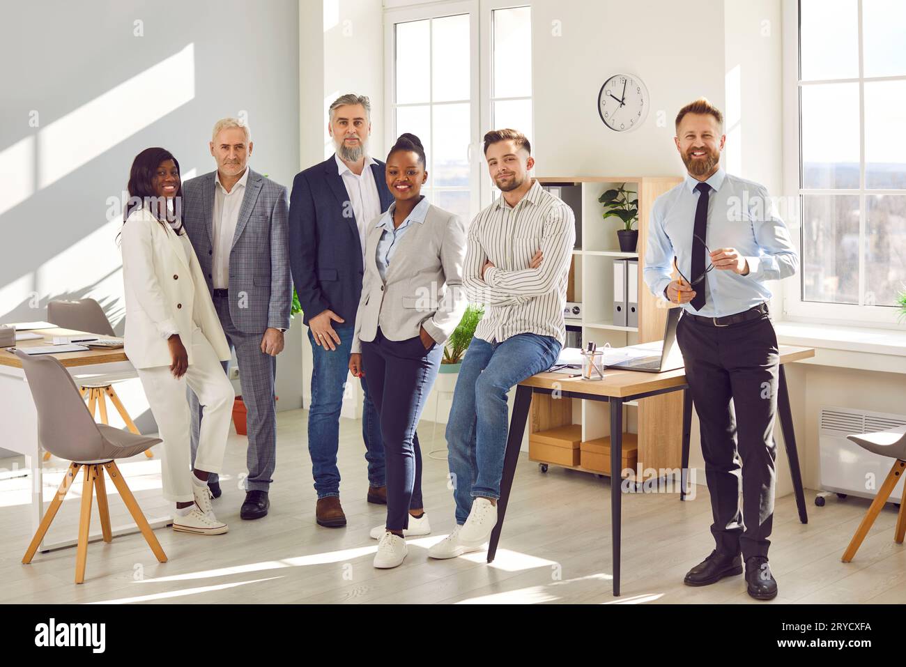 Confident smiling business people standing together in office Stock ...