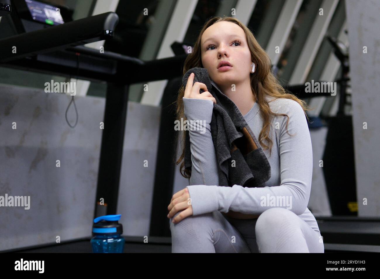 young girl in a gray tracksuit gymsuit In a dark gym, dissolve hair ...