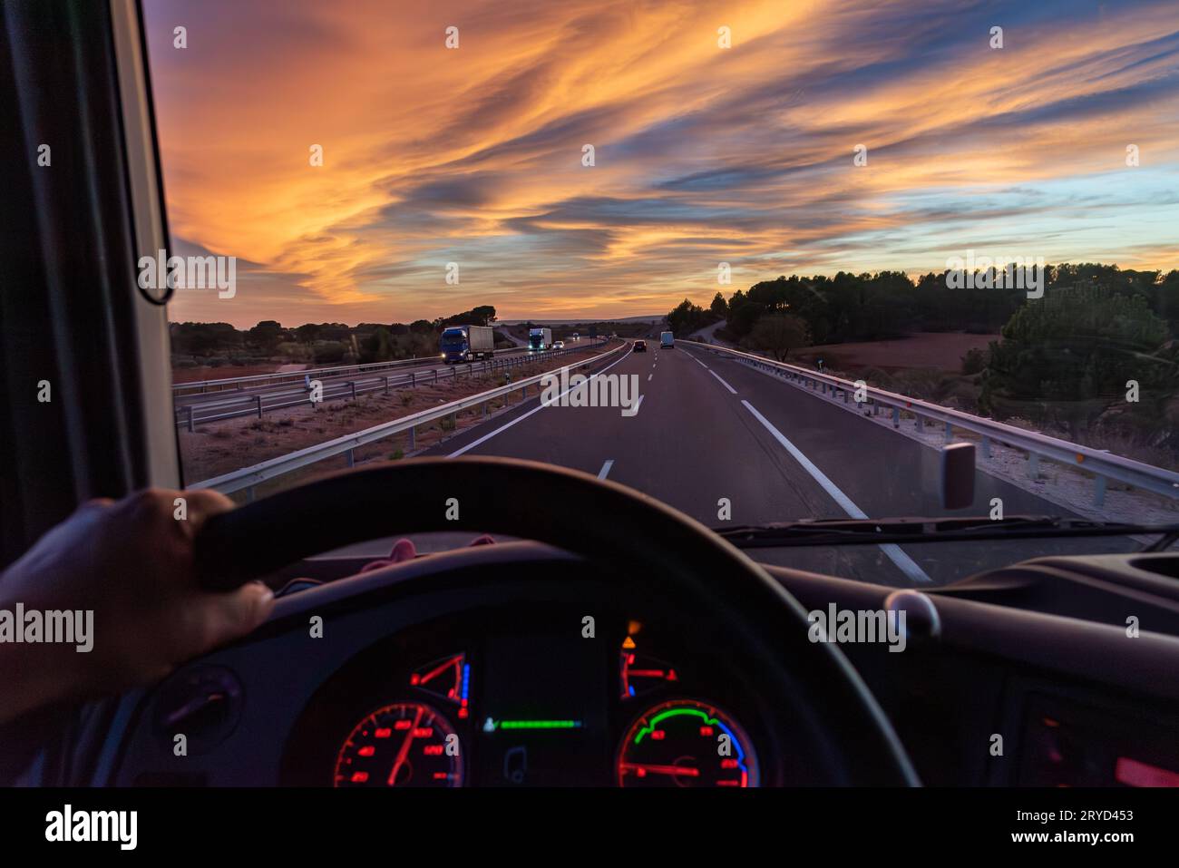 View from the driver's seat of a truck of a highway with vehicles in both directions. Stock Photo