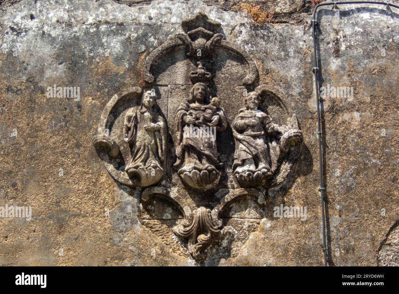 A magnificent relief of the Virgin Mary, Mother of God, on the wall of a not so magnificent ruined and deserted house in the village of Carvalhal in Northern Portugal Stock Photo