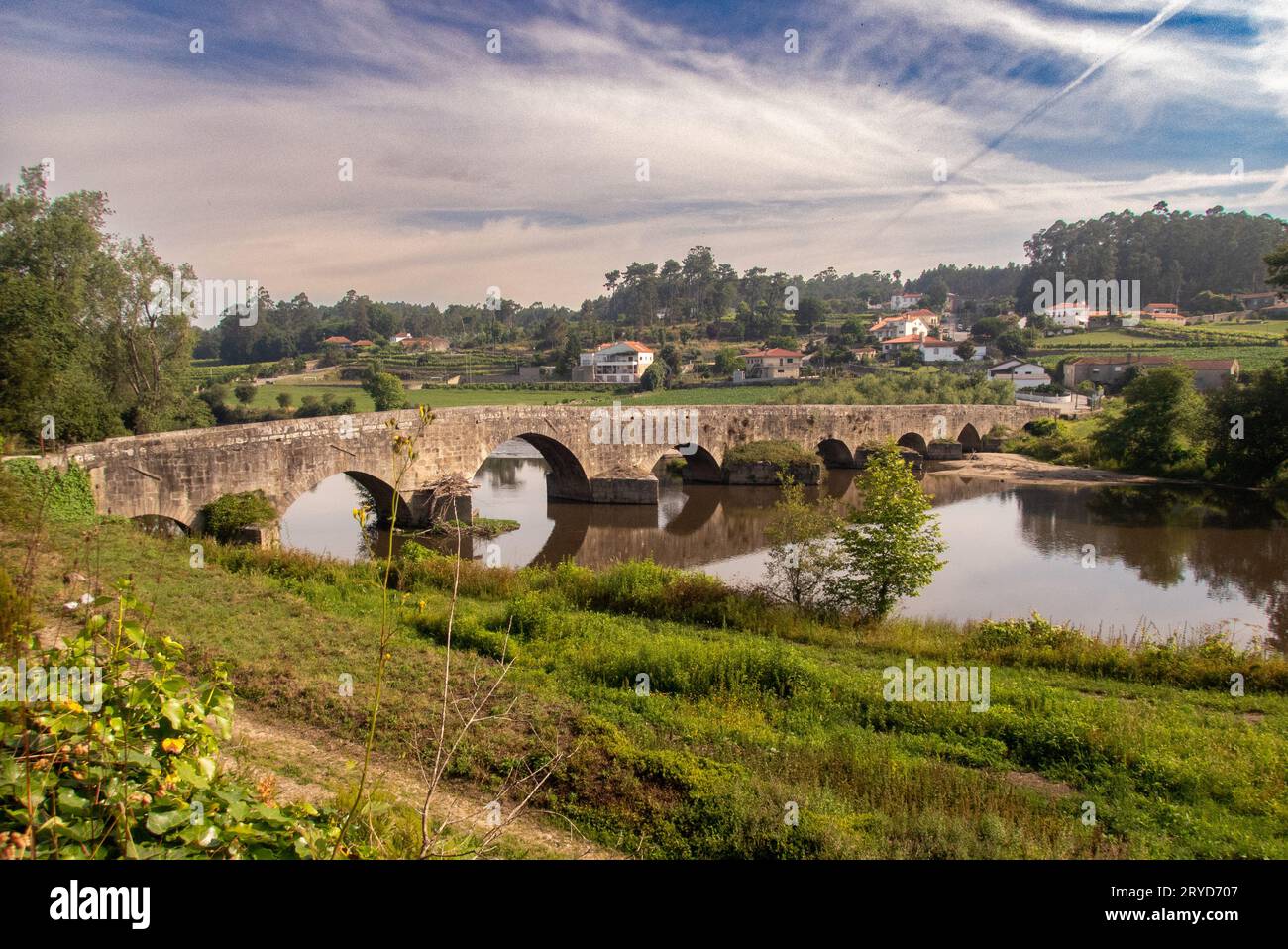 The ancient Roman bridge over the Rio Ave near Vilarinho in Northern Portugal on a quiet summer morning. Stock Photo