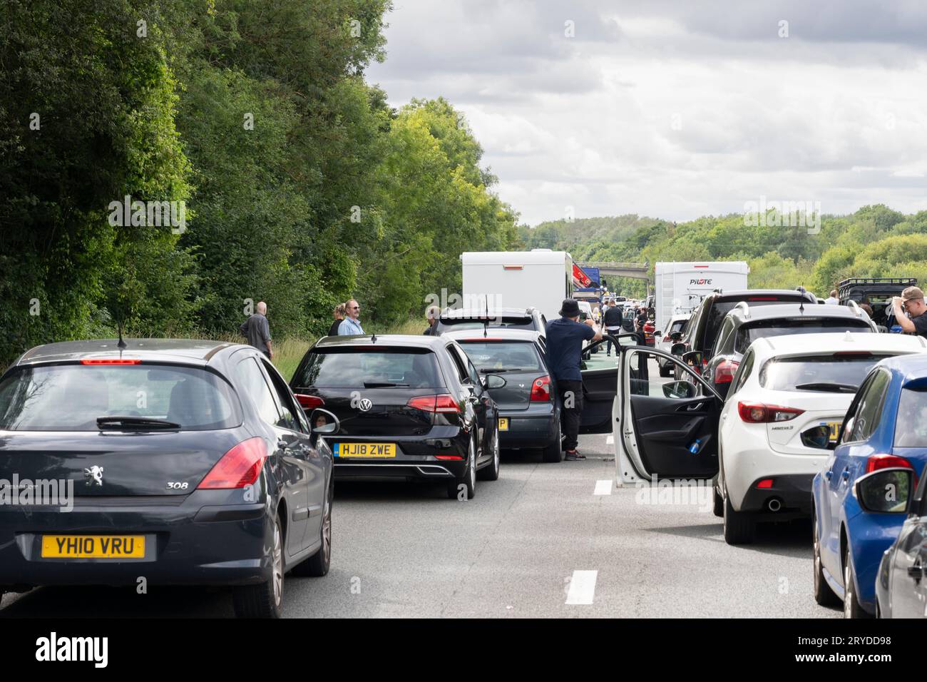 Traffic stopped on the M3 on 13th August 2023 near Basingstoke due to an accident, with people walking on the motorway and stretching their legs. UK Stock Photo