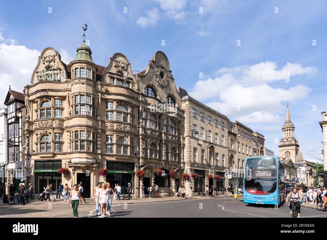 The corner of Cornmarket Street and High Street with the decorated stone facade of Lloyds Bank in central Oxford on a summer's day. England Stock Photo