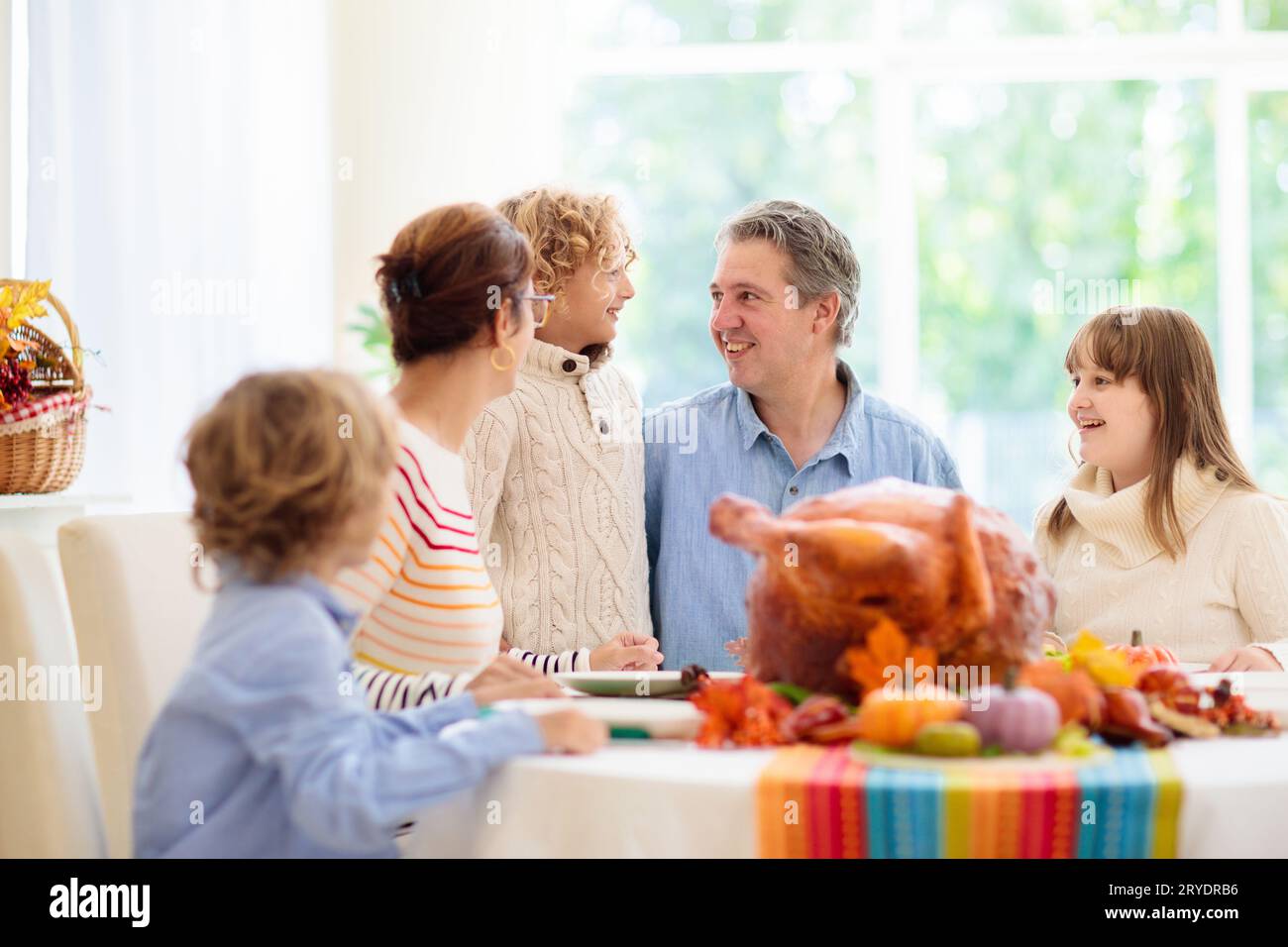 Family at Thanksgiving dinner. Parents and kids enjoy roasted turkey