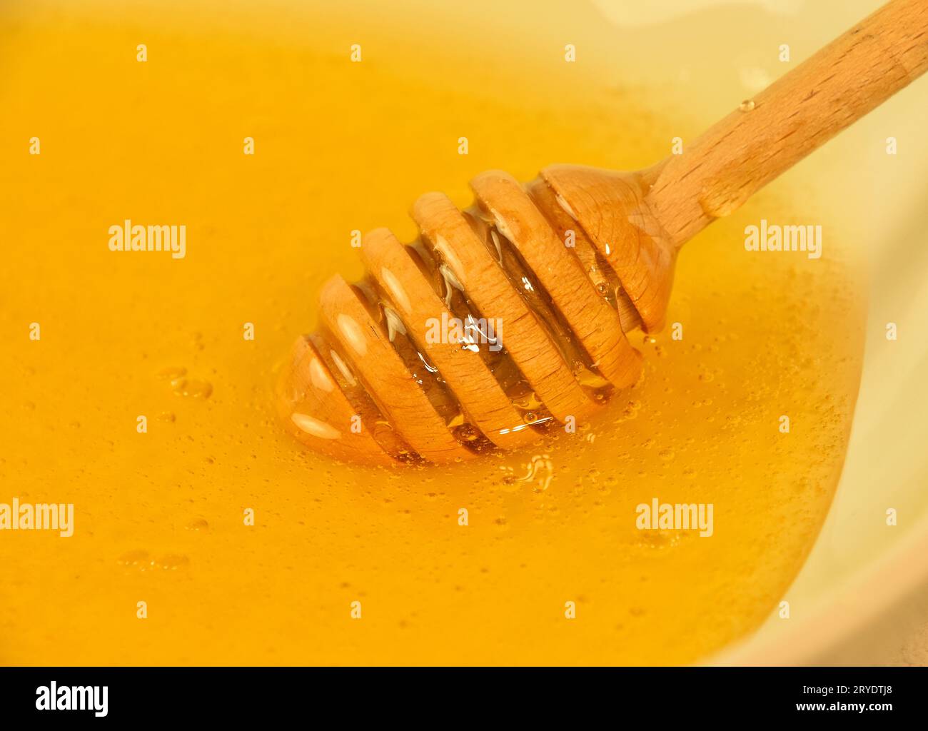 Close up wooden dipper in honey bowl Stock Photo Alamy