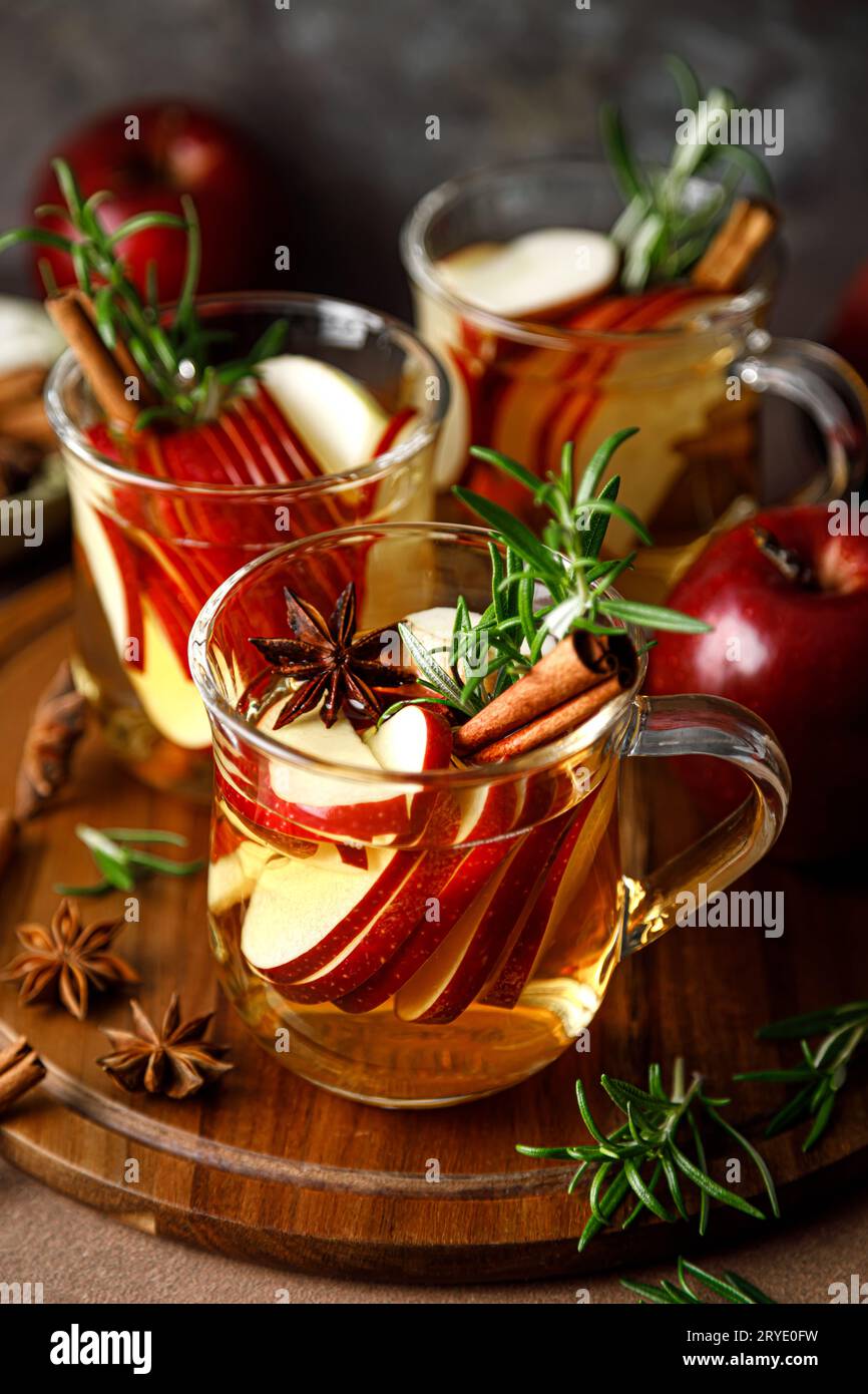Christmas mulled apple cider with cinnamon, anise and rosemary. Traditional hot drink or beverage, festive Xmas or New Year winter cocktail Stock Photo