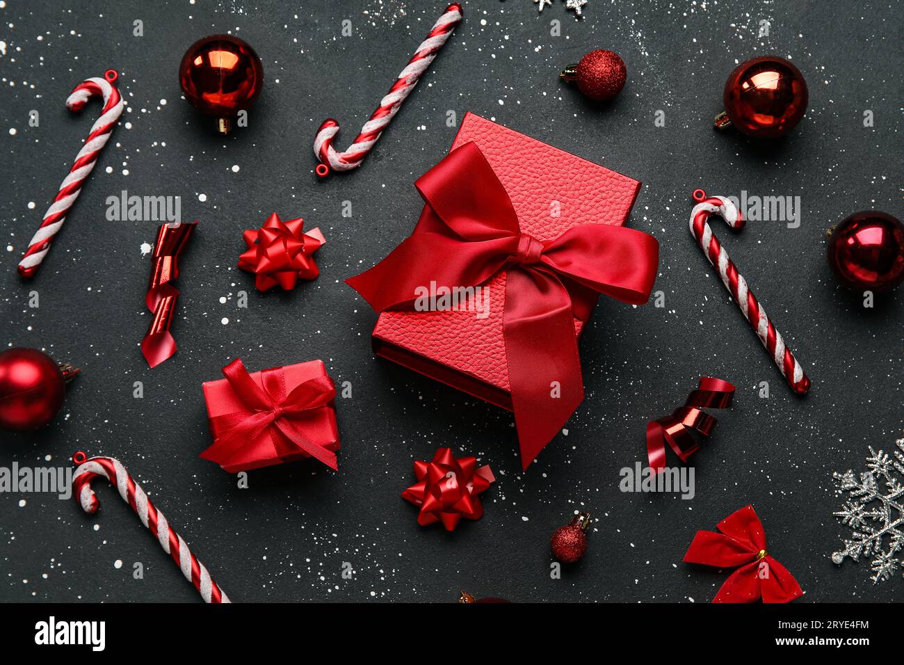 Christmas balls with gift boxes and candy canes on black background ...