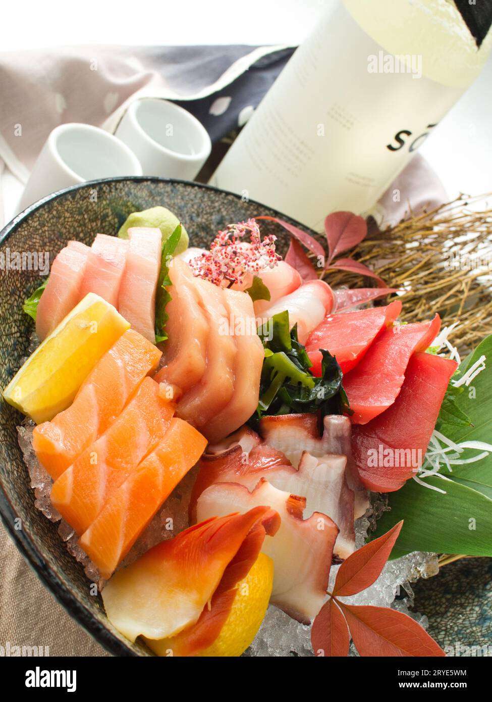 Large bowl of colorful chirashi on crushed ice with sake at Japanese restaurant in Seattle. Stock Photo