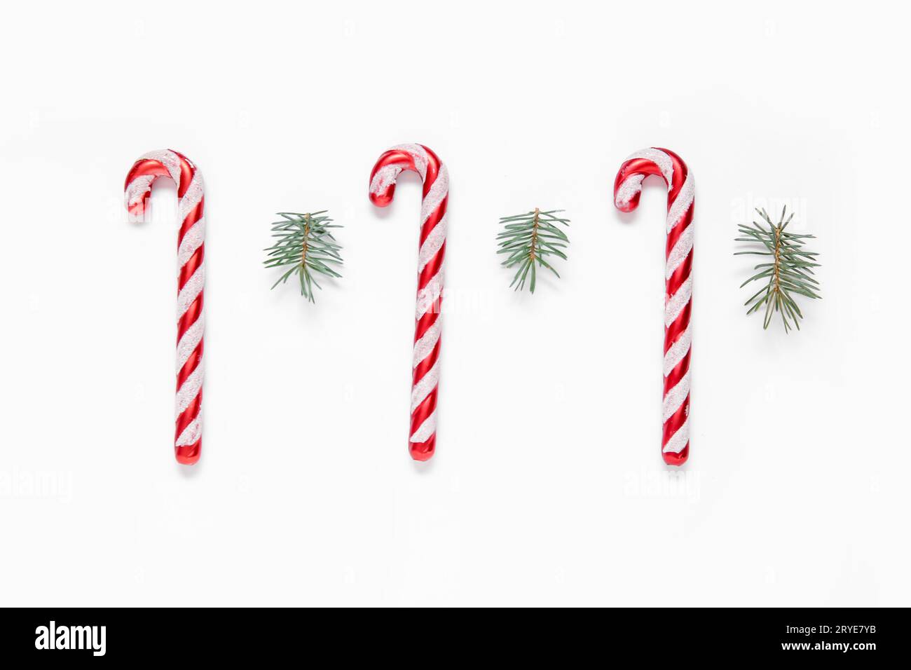 Christmas tree branches and candy canes on white background Stock Photo ...