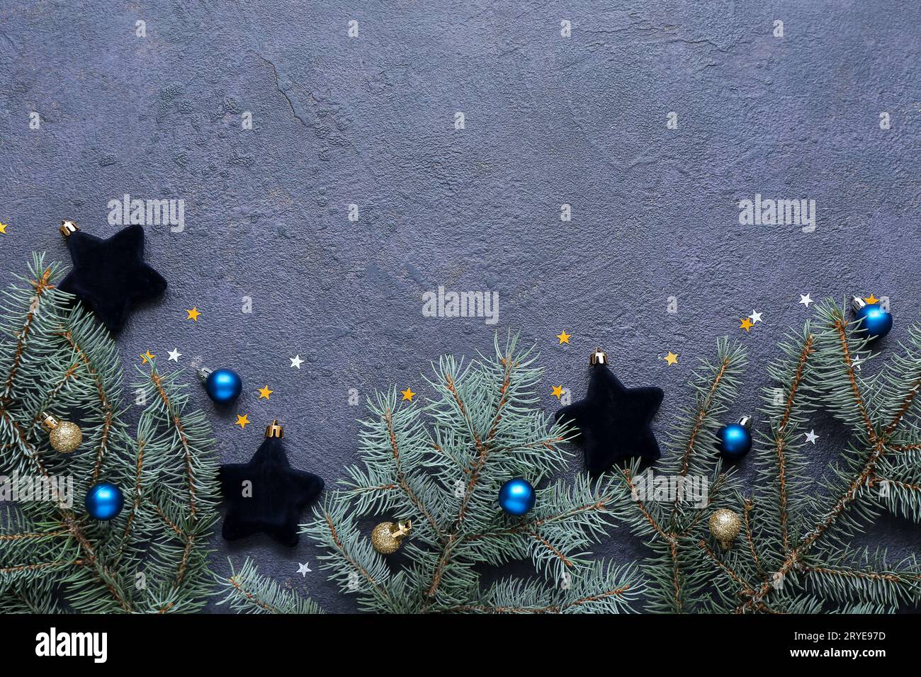 Christmas tree branches with balls and confetti on dark background ...