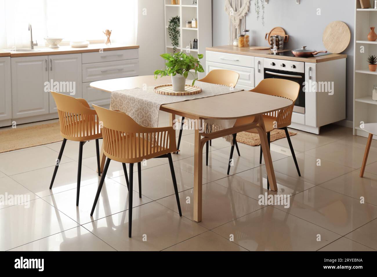 Interior of light kitchen with white counters and dining table Stock ...